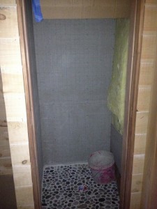 Downstairs shower stall with rock floor